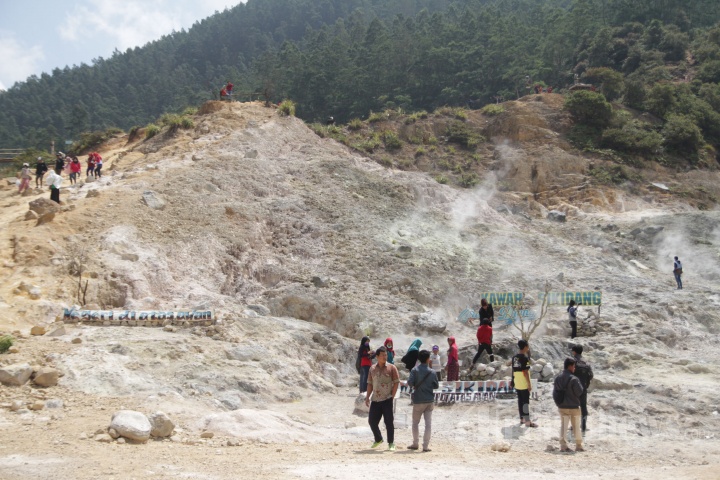 Wisatawan mengunjungi Kawang Sikidang di Kawasan Wisata Dieng di Kabupaten Banjarnegara, Minggu (5/8/2017). Kawah yang masih menunjukkan aktivitas vulkanik menjadi daya tarik pengunjung. 