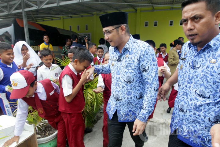 Wakil Wali Kota Palu yang juga personil grup band Ungu, Sigit Purnomo Syamsuddin Said (dua kanan), diserbu anak sekolah yang meminta bersalaman saat menghadiri acara donasi bagi anak-anak korban gempa dan tsunami Palu, di di SD Negeri Palu, Sulawesi Tengah, Senin (17/12/2018). Vokalis yang akrab disapa Pasha Ungu tersebut tidak kehilangan aura keartisannya meski sekarang telah menjadi pejabat publik. 