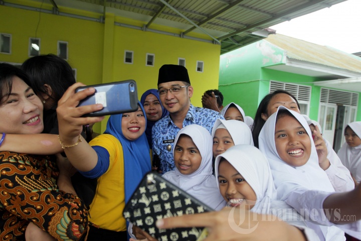 Wakil Wali Kota Palu yang juga personil grup band Ungu, Sigit Purnomo Syamsuddin Said (tengah berbaju batik Korpri), diserbu anak sekolah yang meminta berfoto saat menghadiri acara donasi bagi anak-anak korban gempa dan tsunami Palu, di di SD Negeri Palu, Sulawesi Tengah, Senin (17/12/2018). Vokalis yang akrab disapa Pasha Ungu tersebut tidak kehilangan aura keartisannya meski sekarang telah menjadi pejabat publik. 
