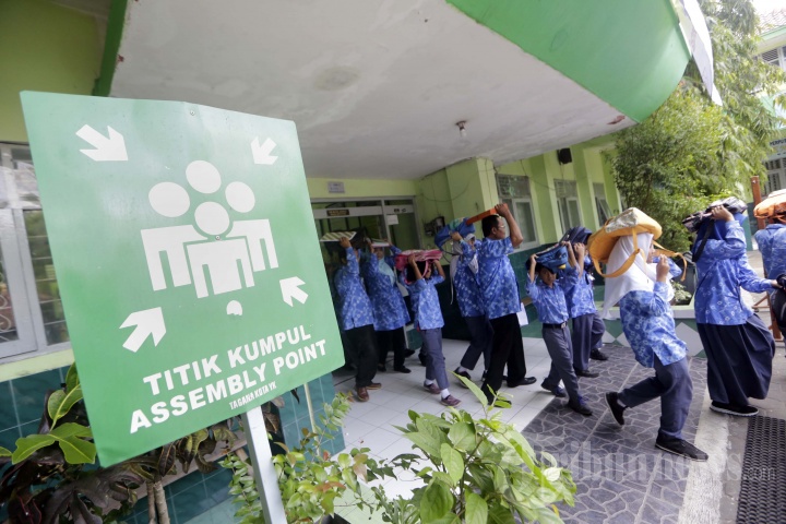Sejumlah siswa berlindung di bawah meja saat berlangsung simulasi bencana gempa bumi di SD negeri Jetisharjo, Kota Yogyakarta, Selasa (5/12/2017).