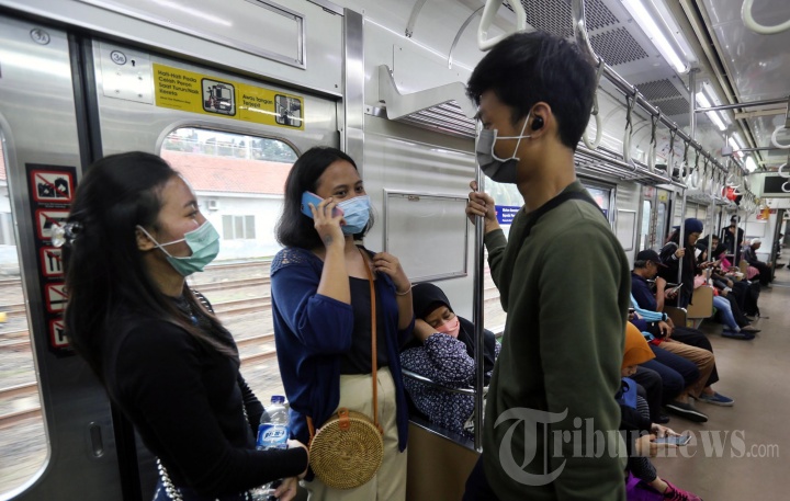 Penumpang KRL Gunakan Masker