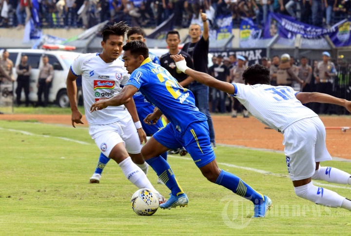 Pemain Persib Bandung Frets Butuan (tengah) berduel dengan pemain Arema FC dalam pertandingan lanjutan Liga 1 di Stadion Si Jalak Harupat, Bandung, Selasa (13/11/2019). Persib Bandung berhasil melumat tamunya Arema FC tiga gol tanpa balas. 