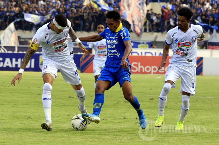 Pemain Persib Bandung Frets Butuan (tengah) dikepung pemain Arema FC Arthur Cunha (kiri) dan Alfin Tuasalamony (kanan) dalam pertandingan lanjutan Liga 1 di Stadion Si Jalak Harupat, Bandung, Selasa (13/11/2019).