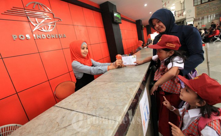 Petugas keamanan membantu siswa sekolah dasar yang mengirim surat di Kantor Pos Besar Bandung, Jalan Asia Afrika, Kota Bandung, Rabu (30/9/2015). Di usianya yang ke-269 tahun, PT Pos Indonesia berusaha berbuat yang terbaik dalam melayani masyarakat pada umumnya dan untuk pelanggan yang selalu menggunakan layanan pos, dalam memenuhi kebutuhan aktivitas kesehariannya. 