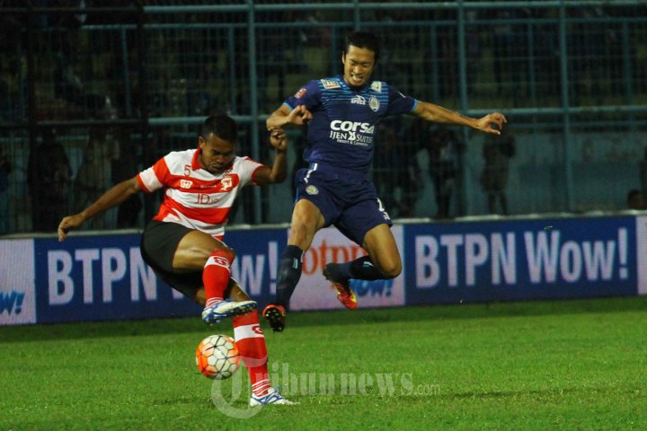 Arif Suyono, winger Arema Cronus berebut bola dengan Munhar, bek Madura United dalam lanjutan Indonesia Soccer Championship (ISC) di Stadion Kanjuruhan Kepanjen, Kabupaten Malang, Jumat (2/9/2016). Pada akhir babak pertama Arema Cronus ditahan imbang Madura United dengan skor 1-1. 