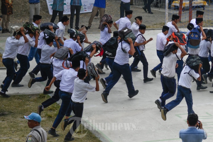 Siswa berusaha menyelamatkan diri saat alarm tsunami berbunyi dalam simulasi bencana gempa dan tsunami di Dayah Insafuddin, Lambaro Skep, Kecamatan Kuta Alam, Banda Aceh, Senin (19/2/2018).