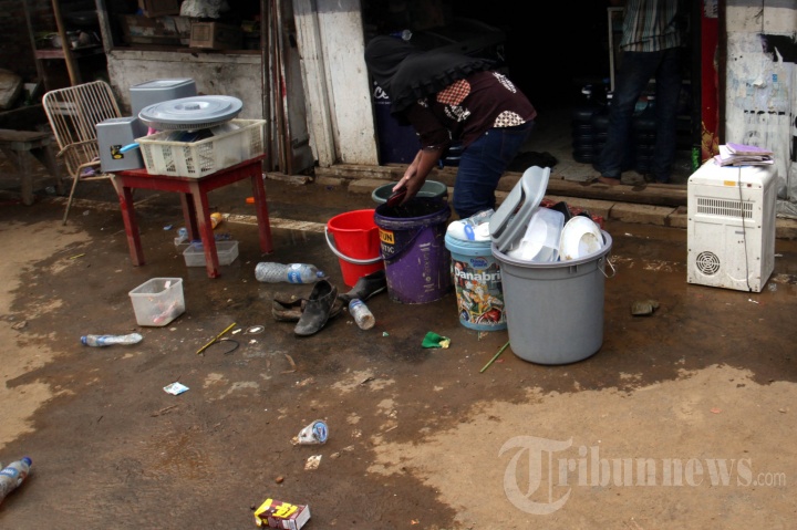 Warga Bersihkan Peralatan Rumah Tangga yang Terendam Banjir