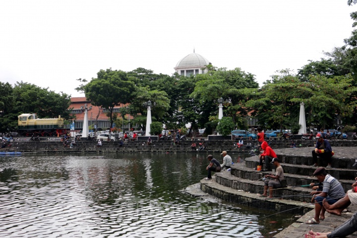 Warga Memancing di Kolam Polder Tawang