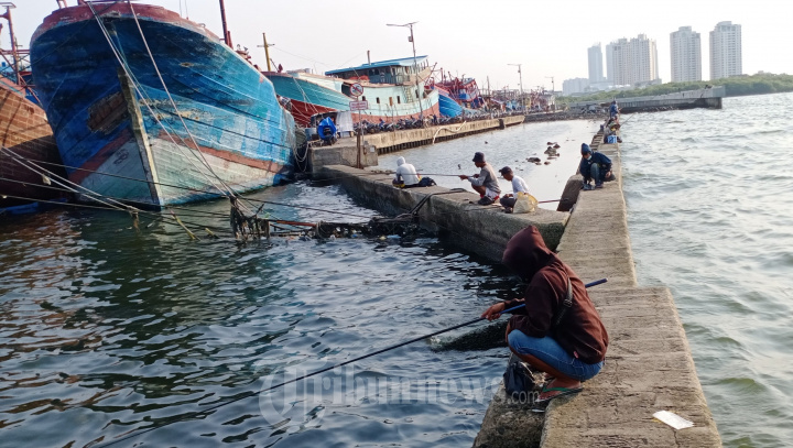 Warga Memancing Ikan di Muara Baru Jakarta