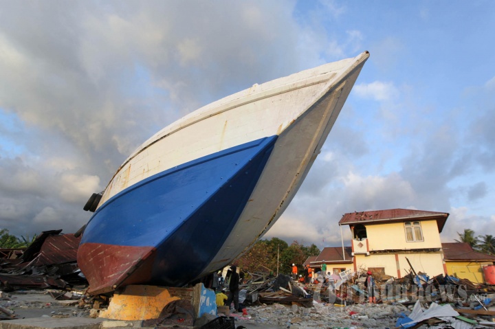 Warga Mencari Barang Berharga di Atas Puing-puing Rumahnya