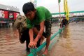 Brimob Evakuasi Korban Banjir Kampung Melayu