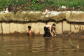 Anak-anak Nekat Berenang di Bantaran Sungai Ciliwung