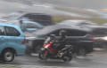 Pengendara Motor Nekat Terjang Hujan Deras Disela Mobil