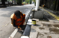 Petugas PPSU Rawamangun Mengecat Trotoar di Jalan Ahmad 