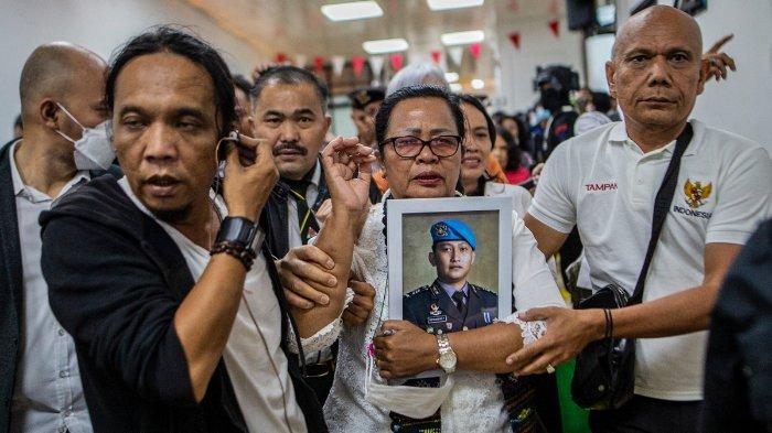 Rosti Simanjuntak (tengah), ibunda mendiang Brigadir Nofriansyah Yosua Hutabarat, memegang foto anaknya usai mantan Kabid Humas Polri Ferdy Sambo divonis mati dalam sidang pembacaan vonis di Pengadilan Negeri Jakarta Selatan, Jakarta, Februari lalu. 13 Agustus 2023. Sambo dijatuhi hukuman mati pada hari Senin atas pembunuhan pengawalnya Hutabarat dalam persidangan tingkat tinggi yang dipandang sebagai ujian akuntabilitas kepolisian negara.