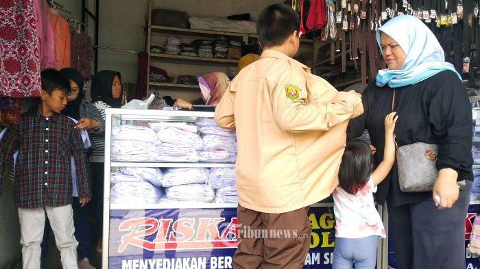 Orang tua mengajak anaknya membeli seragam sekolah di salah satu toko perlengkapan seragam sekolah, di Jalan Cipaera, Kosambi, Kota Bandung, Jawa Barat, Senin (10/7/2023). Sepekan menjelang masuk sekolah memasuki tahun ajaran baru 2023 sejumlah toko perlengkapan seragam sekolah di kawasan tersebut ramai dikunjungi pembeli.- Berikut aturan seragam sekolah bagi siswa Sekolah Dasar (SD), Sekolah Menengah Pertama (SMP), dan Sekolah Menengah Atas (SMA).