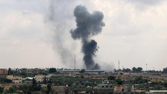 Asap mengepul dari perbatasan Rafah Gaza dengan Mesir saat serangan udara Israel pada 10 Oktober 2023. Perbatasan Gaza dengan Mesir, satu-satunya yang melewati Israel, terkena serangan udara Israel pada 10 Oktober 2023 untuk kedua kalinya di 24 jam, kata para saksi dan kelompok hak asasi manusia. Para saksi mata mengatakan serangan itu menghantam tanah tak bertuan antara gerbang Mesir dan Palestina, sehingga merusak aula di sisi Palestina.