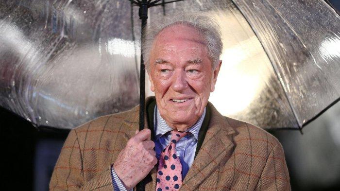 Aktor Inggris Michael Gambon berlindung dari hujan saat ia tiba untuk pemutaran perdana film Dad's Army di London pada 26 Januari 2016.
