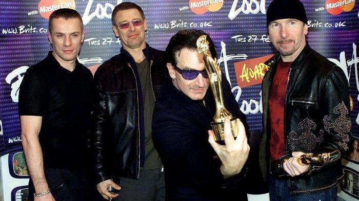 Penyanyi utama U2 Bono (2 kanan) memegang piala saat anggota band Larry Mullen Jr (kiri), Adam Clayton (2 kiri) dan The Edge (kanan) menyaksikan setelah memenangkan Grup Internasional Terbaik dan penghargaan pencapaian seumur hidup khusus selama Brits di arena Earls Court di London 26 Februari 2001. Brit Awards adalah industri musik Inggris yang setara dengan Grammy, upacara penghargaan musik terbesar dan paling dihormati tahun ini.