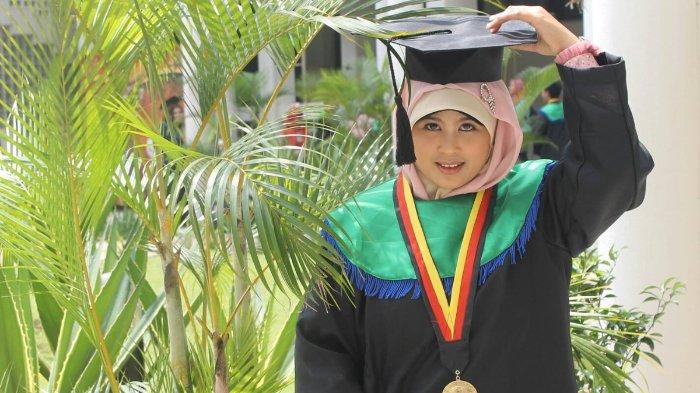 Mengenakan toga bewarna hitam dan hijau ketika wisuda sarjananya
