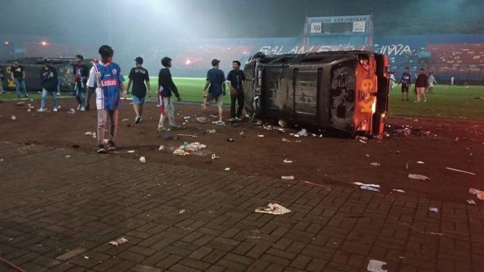 Mobil K-9 dibalik oleh supporter Aremania dalam kericuhan yang terjadi di Stadion Kanjuruhan, Sabtu (1/10/2022)