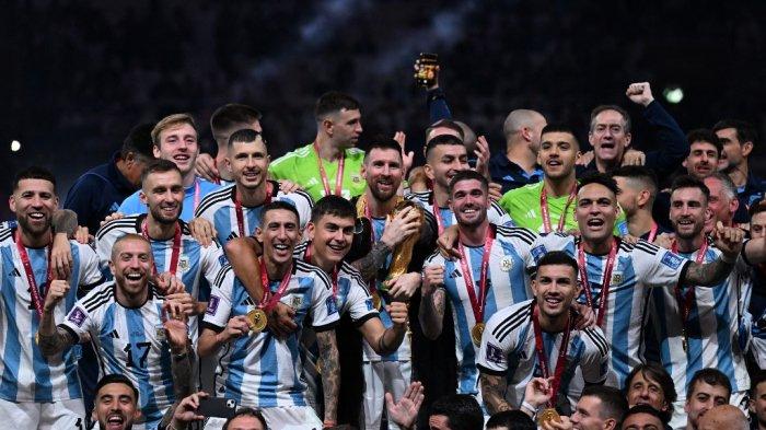 Penyerang Argentina #10 Lionel Messi (tengah) memegang Trofi Piala Dunia FIFA saat ia merayakan kemenangan bersama rekan satu timnya dalam pertandingan sepak bola final Piala Dunia 2022 Qatar antara Argentina dan Prancis di Stadion Lusail di Lusail, utara Doha pada 18 Desember 2022.