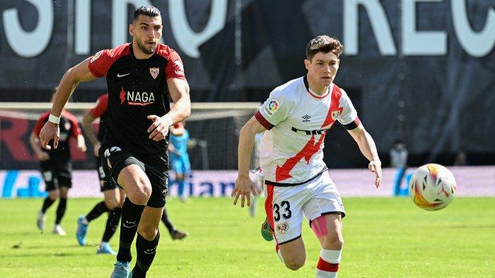 Penyerang Sevilla asal Spanyol Rafa Mir (kiri) berebut bola dengan bek Spanyol Rayo Vallecano Fran Garcia selama pertandingan sepak bola liga Spanyol antara Rayo Vallecano de Madrid dan Sevilla FC di stadion Vallecas di Madrid pada 13 Maret 2022.