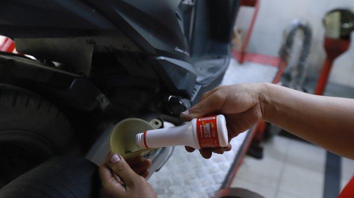 Salah satu teknisi AHASS sedang melakukan pembersihan jalur pelumas