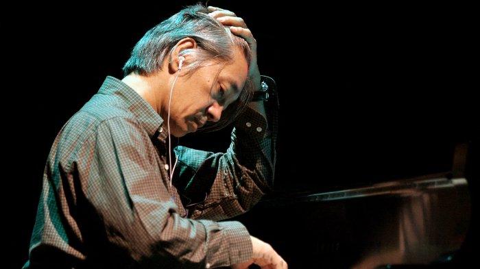 Komposer Jepang pemenang penghargaan Ryuichi Sakamoto memainkan piano akustik selama latihan konser media campurannya 