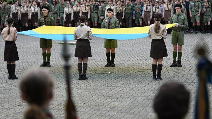 Anggota Organisasi Kepanduan Nasional Plast memegang bendera raksasa Ukraina saat mereka menghadiri upacara untuk memperingati 111 tahun berdirinya Plast di kota Lviv, Ukraina barat, pada 22 April 2023, di tengah invasi Rusia di Ukraina.