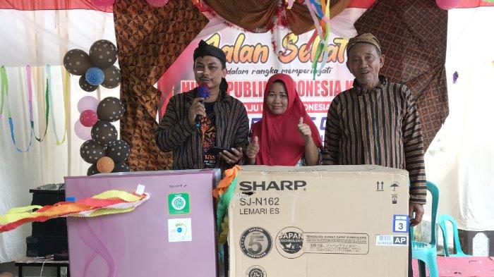 Yusuf (kiri), Munaroh (tengah), Raeso (kanan) sedang berfoto dengan kulkas yang menjadi hadiah utama pada jalan sehat & karnaval warga RT 04 Desa Babalan Kidul, Kec. Bojong, Pekalongan, Minggu (20/8/2023).