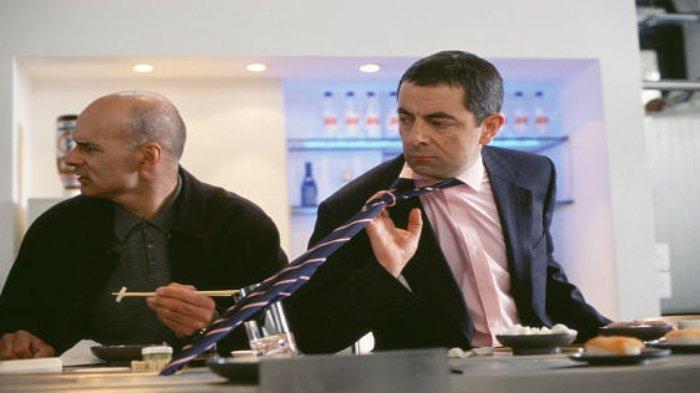 Aksi Johnny English (Rowan Atkinson) di film Johnny English (2003).
