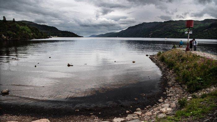 Pengunjung melihat perairan Loch Ness yang mengalami ketinggian air lebih rendah dari rata-rata, pada 6 Juli 2023, di Dataran Tinggi Skotlandia. Danau tersebut, yang dikenal di seluruh dunia karena monster mistisnya yang bersembunyi di kegelapan celah bawah air, telah berbagi rahasianya dengan Mangus namun musim panas ini ia melukiskan gambaran yang belum pernah dilihatnya sebelumnya - permukaan air telah tenggelam lebih rendah dan tetap berada di sana. lebih lama dari waktu mana pun dalam ingatannya. “Saya belum pernah melihatnya serendah ini,” kata Gordon Mangus kepada AFP di pelabuhan danau di luar kota Drumnadrochit.