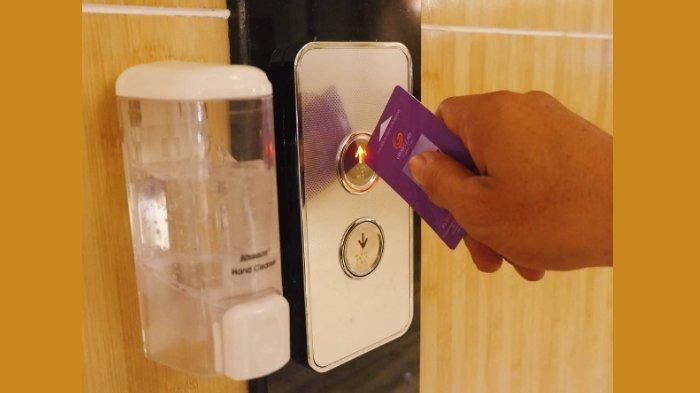 Menekan tombol elevator menggunakan keycard yang sudah disemprot disinfektan.