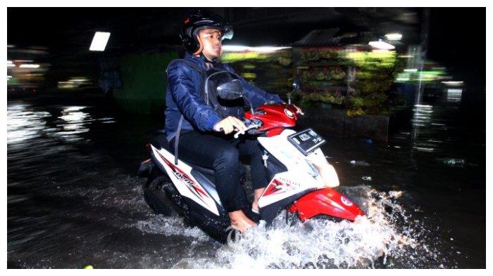 Mengendarai sepeda motor ketika hujan