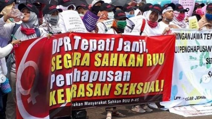 Peserta aksi dengan membawa spanduk tuntutan
