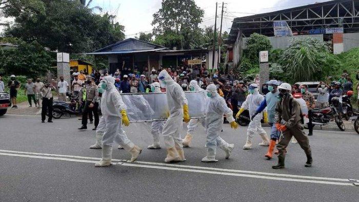 Tim gugus Tugas Covid-19 menyiagakan sebuah mobil ambulans untuk membawa kembali jasad pasien Covid-19 yang sebelumnya diambil paksa pihak keluarga, Jumat (26/6/2020). Upaya membawa kembali jenazah Covid-19 itu ikut dikawal ratusan anggota polisi di kawasan tersebut(KOMPAS.COM/RAHMAT RAHMAN PATTY)