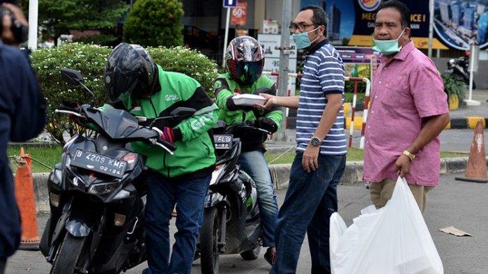 sukarelawan bagikan makanan ke ojol