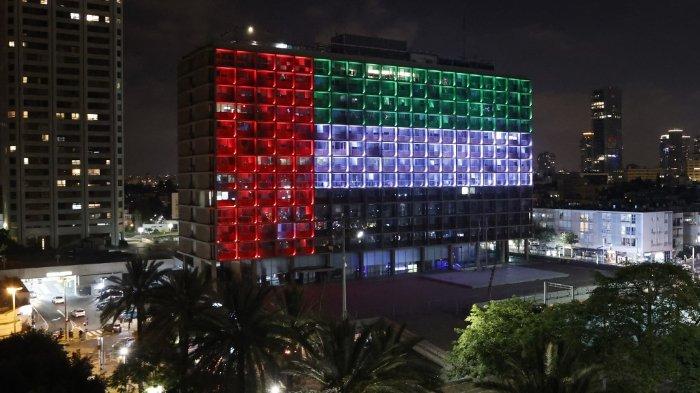 FOTO: Sebuah bangunan di pesisir kota Israel, Tel Aviv diterangi dengan warna bendera nasional Uni Emirat Arab pada 13 Agustus 2020. Israel dan UEA setuju untuk menormalisasi hubungan yang ditengahi AS. Perjanjian tersebut, yang pertama kali diumumkan oleh Presiden AS Donald Trump di Twitter, akan membuat Israel menghentikan rencananya untuk menganeksasi sebagian besar Tepi Barat yang diduduki, menurut UEA.