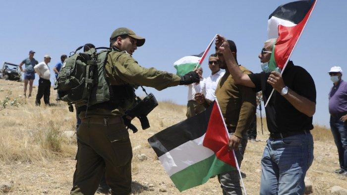 FOTO: Seorang tentara Israel berbicara kepada pengunjuk rasa pro-Palestina selama demonstrasi menentang pendirian pos pemukiman di Lembah Jordan, timur kota Tubas, di Tepi Barat yang diduduki, pada 6 Agustus 2020.