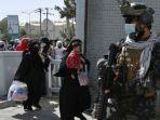 Pejuang-Taliban-Badri-berjaga-jaga-di-gerbang-masuk-utama-bandara-Kabul.jpg