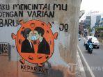 Warga-melintas-di-depan-mural-sosialisasi-bahaya-COVID-19-di-Jakarta.jpg