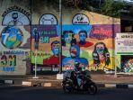 melintasi-mural-berisi-pesan-ajakan-menggunakan-masker.jpg
