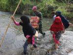 sejumlah-masyarakat-dan-tni-melintasi-sungai-sambil-membawa-sembako.jpg