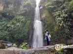seorang-wisatawan-sedang-berfoto-di-bawah-air-terjun-coban-talun-kota-batu.jpg
