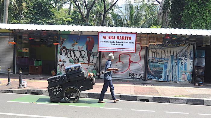 PASAR BARITO DIGUSUR - Tukang loak melintas didepan toko pedagang hewan di Pasar Hewan Barito, Kebayoran Baru, Jakarta Selatan, Sabtu (2/8/2025). Pemerintah kota Jakarta Selatan akan membantu pedagang Pasar Barito untuk pindah ke lokasi sementara sebelum lokasi binaan di Pasar Minggu dan Lenteng Agung siap ditempati. Warta Kota/Yulianto