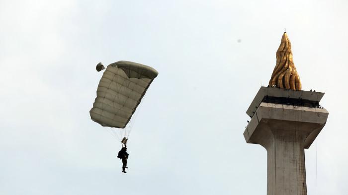 GLADI BERSIH - Penerjun payung melintas di atas tugu Monas saat gladi bersih Hari Ulang Tahun (HUT) ke-80 Tentara Nasional Indonesia (TNI) di Monas, Gambir, Jakarta Pusat, Jumat (3/10/2025). Gladi bersih tersebut digelar dalam rangka persiapan HUT ke-80 TNI yang mengerahkan sekitar 133 ribu personel dan 1.047 alat utama sistem persenjataan (alutsista) pada Minggu, 5 Oktober 2025. Warta Kota/Yulianto