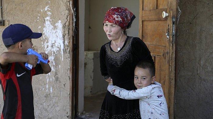 Alif Baqytali memeluk ibunya, Gulnar Omirzakh, di rumah baru mereka di Shonzhy, Kazakhstan. Omirzakh, etnik Kazakh kelahiran China, mengatakan dia dipaksa untuk mendapatkan alat kontrasepsi dalam kandungan dan pihak berwenang di China mengancam akan menahannya jika dia tidak membayar denda besar karena melahirkan Alif, anak ketiganya. 