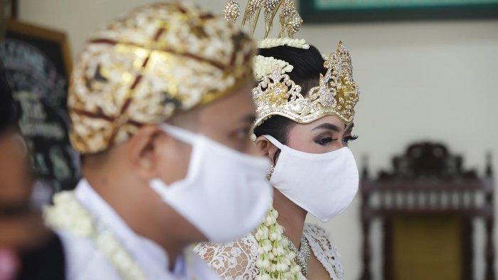 Pasangan pengantin menggunakan masker saat melaksanakan prosesi akad nikah di Kantor Urusan Agama (KUA) Ciracas, Jakarta, Sabtu (6/6/2020).
