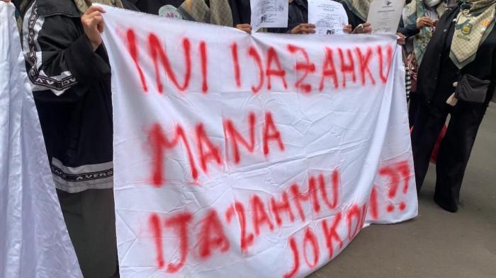 DUKUNGAN ROY SURYO CS - Puluhan simpatisan Roy Suryo Cs hadir memberikan dukungan di Polda Metro Jaya. Mayoritas pendukung merupakan emak-emak yang membawa spanduk berisi tulisan 